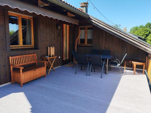 a deck with a table and chairs on a house at Ferienwohnung Mei Ruh' in Burggen