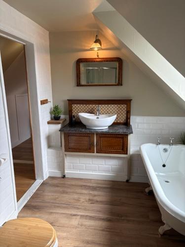 a bathroom with a sink and a bath tub at Highland Rooms - Room Only No Breakfast in Ullapool