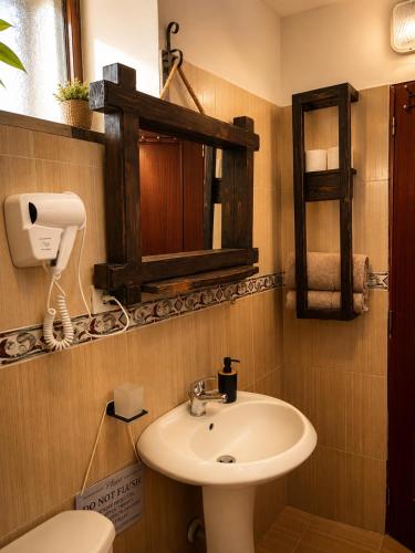 a bathroom with a sink and a toilet and a mirror at Forest House in Berat