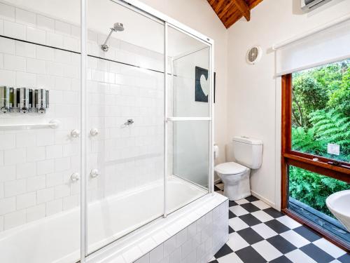 a bathroom with a shower and a sink and a toilet at Risehill House in Kalorama