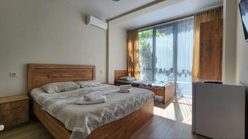 a bedroom with a bed and a large window at Best House in Kobuleti