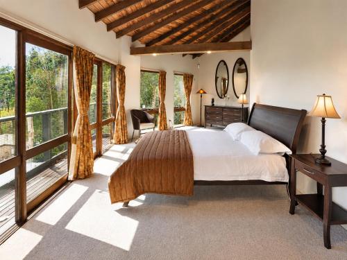 a bedroom with a large bed and large windows at Risehill House in Kalorama