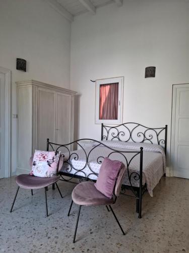 a bedroom with a bed with two chairs in it at Borghetto sant'irene in Erchie