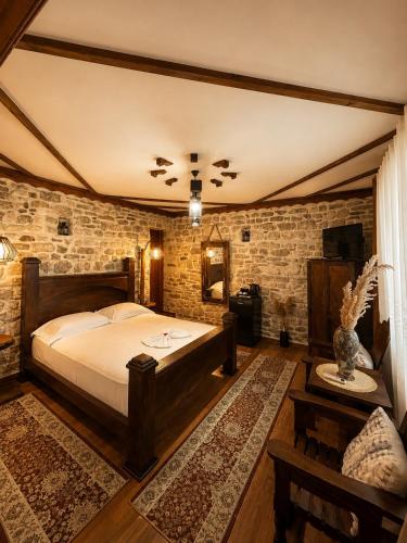 a bedroom with a bed and a brick wall at Forest House in Berat