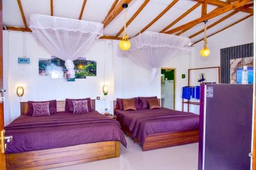 two beds in a room with white walls and wooden ceilings at Ella Black Bridge Grand View Cottage Sri Lanka in Ella