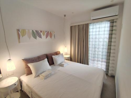 a bedroom with a large white bed with a window at Kleopatra's residence in Bendevís