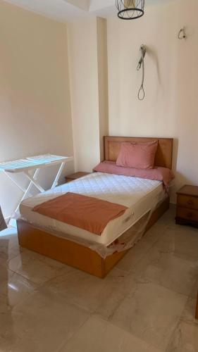 a bedroom with a large bed with pink pillows at Cozy studio in sahel in El Alamein