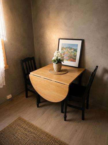 a dining room table with a vase of flowers on it at Linken Studio for 2 in Narvik