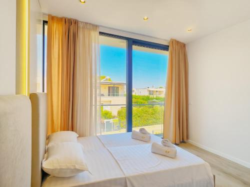 a bedroom with a bed and a large window at Azure Garden Villa 317 in Lalzit Bay