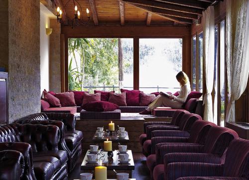 a woman sitting on a couch in a living room at Country Club Hotel & Suites in Mikrón Khoríon