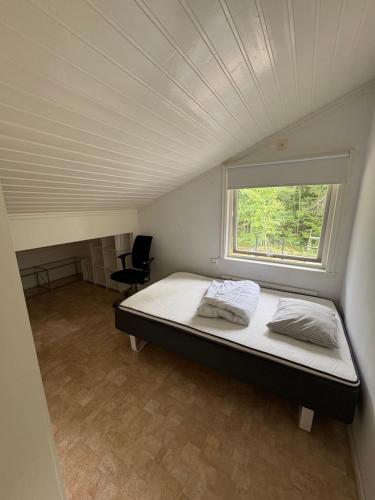 a bed in a small room with a window at Semesterparadis in Strömstad