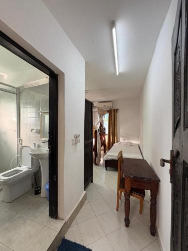 a bathroom with a bed and a sink and a toilet at Villa Tuffah in Watamu