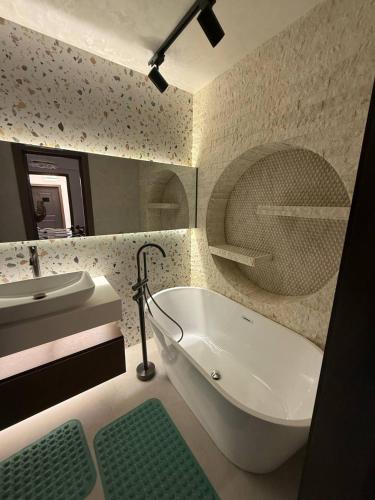 a bathroom with a white tub and a sink at Luxury Comfort Double Room in Bukhara