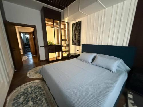a bedroom with a large bed with a blue headboard at Luxury Comfort Double Room in Bukhara