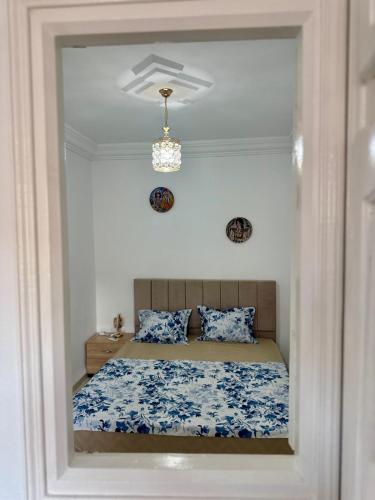 a bedroom with a bed with blue and white sheets at Le Minaret in Kairouan