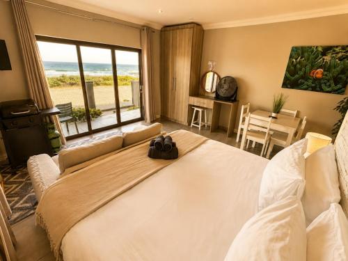 a bedroom with a large bed with a view of the ocean at White Sands Self-catering units in Wilderness
