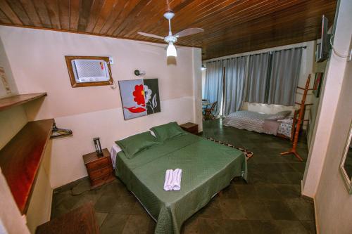 a bedroom with a bed and a ceiling fan at Pousada Miramar in Marataizes