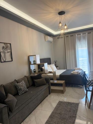 a living room with a couch and a bed at Greysuites in Kavála