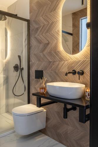 a bathroom with a sink and a toilet and a shower at Residence Tatrzański Park in Poronin
