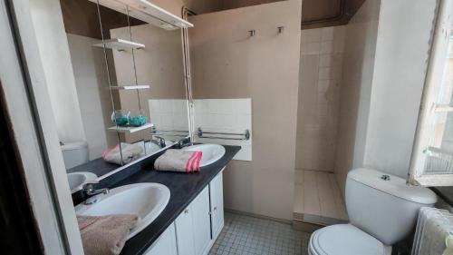 a bathroom with two sinks and a toilet at Chambres d'Hôtes Le Clos Ambels in Ambialet