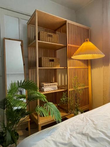 a wooden book shelf with a mirror and a lamp at Busan Harbor Stay in Busan