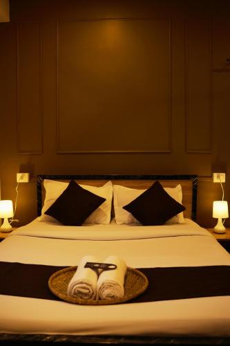 a bed with two towels and a pair of scissors on it at The Guwahati Penthouse in Guwahati