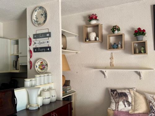 a room with shelves on the wall with a cat on a chair at La Maison de Marianne in Fleury
