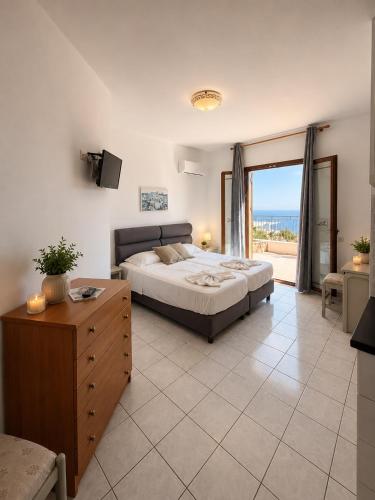ein Schlafzimmer mit Bett und Meerblick in der Unterkunft Aristomenis Studios in Vlachata