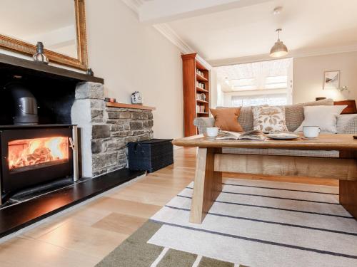 a living room with a couch and a fireplace at Mill View in Aberfeldy