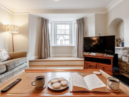 a living room with a coffee table and a tv at Mill View in Aberfeldy