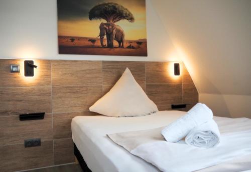 a hotel room with two beds and a picture of an elephant at Hotel Gasthaus Krone in Cologne
