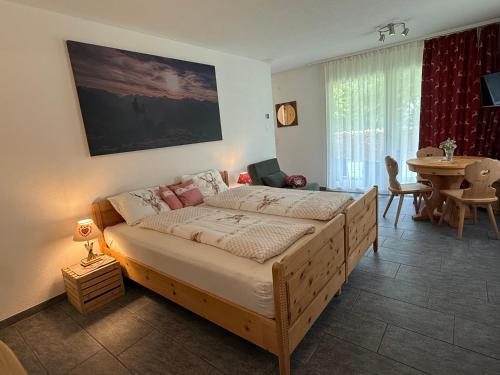 a bedroom with a large bed with a table and a window at Magic Moments in Brail