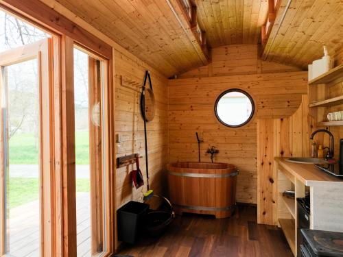 a large wooden tub in a kitchen with a window at Maringotka Bára in Huslenky