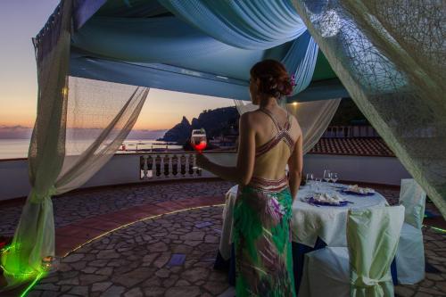a woman holding a glass of wine in a tent at Hotel Village Eden in Capo Vaticano