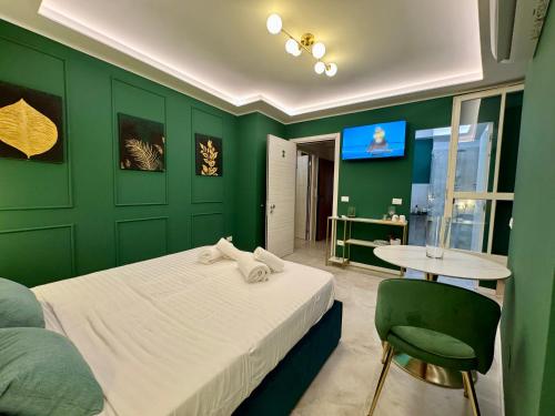 a green bedroom with a bed and a table at Duomo Next Accomodations in Trento