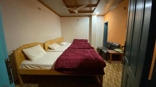 a bedroom with a bed with a red blanket on it at Moon Palace by MZ Hotels Pakistan KPK in Mingāora