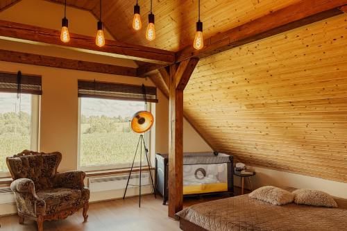 a room with a bed and a chair and a television at Vējkalni in Myza Dzirtsiyems
