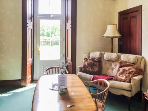 a living room with a table and a couch at Gladstone Cottage in Castletown
