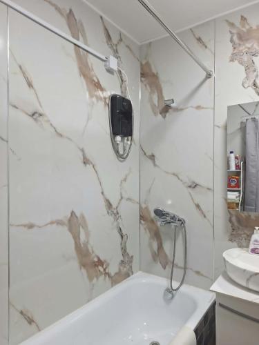 a bathroom with a shower and a tub and a sink at Undraa's cosy small apt in Ulaanbaatar
