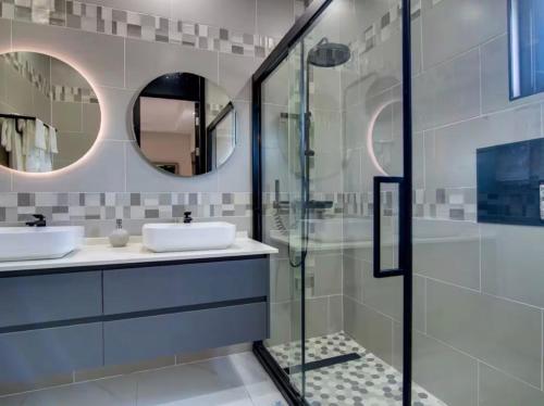 a bathroom with two sinks and a glass shower at The St Ann Haven in Seville