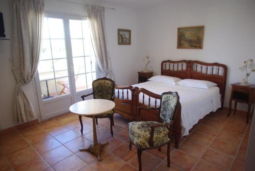 a bedroom with a bed and a table and chairs at Le Mas de l'Amandier in Saint-Saturnin-lès-Avignon