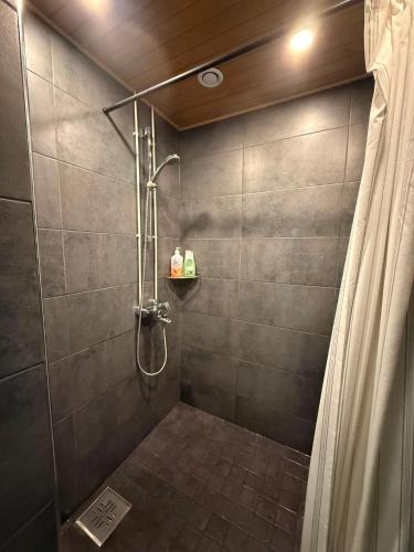 a shower stall with a shower curtain in a bathroom at Matkakoti Patria Hostel - single & double rooms in Lahti