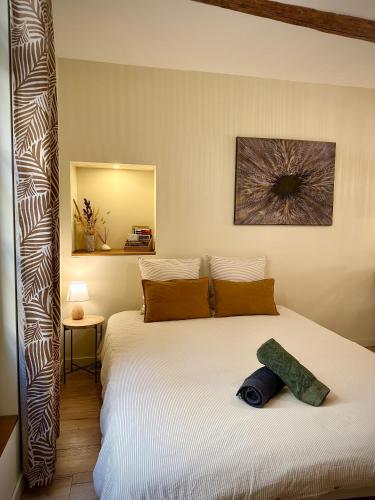 a bedroom with a large white bed with a mirror at Studio centre historique - Climatisé in Pézenas