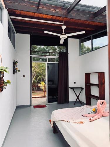 a bedroom with a bed and a ceiling fan at Glass Roof Southern Edge Cabanas in Tangalle