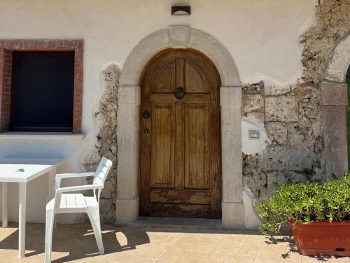 a wooden door in a building with a white chair at La Sorgente Alta in Rocchetta a Volturno