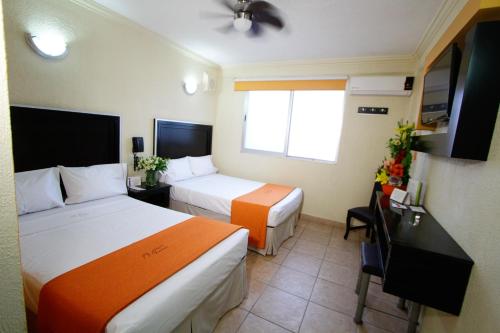 um quarto de hotel com duas camas e uma secretária em Hotel Estadio em Guadalajara
