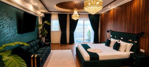 a bedroom with a bed and a couch and a chandelier at Virginia Gardens in Băile Govora