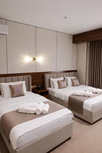 a hotel room with two beds with towels on them at GRAND CARAVAN in Tashkent