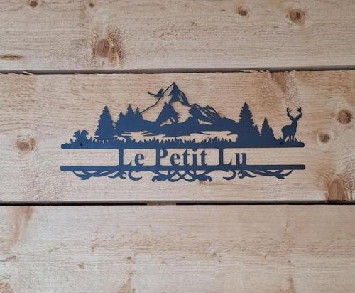 a wood sign of a train with a mountain at Le Petit Lu in Leysin