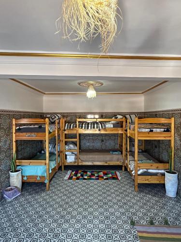 two bunk beds in a room with a ceiling at Ifni Flow Seafront surfhouse in Sidi Ifni